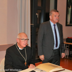 Regionalbischof Stiegler trägt sich ins Goldene Buch ein